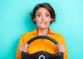 woman holding steering wheel is nervous about the future