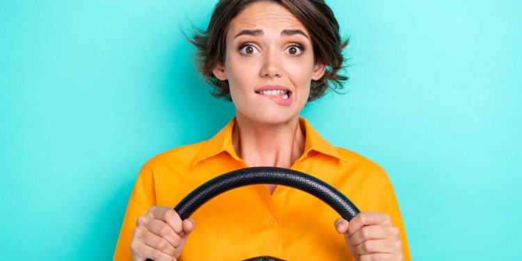 woman holding steering wheel is nervous about the future