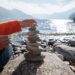 person stacking rocks by the lake