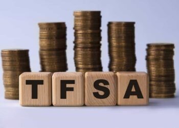 TFSA (Tax free savings account) acronym on wooden cubes on the background of stacks of coins