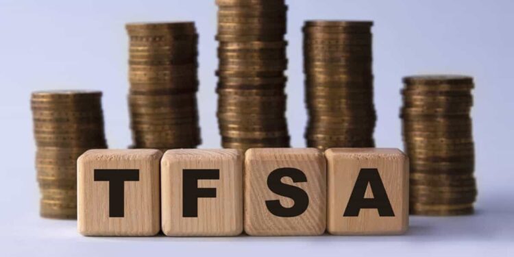 TFSA (Tax free savings account) acronym on wooden cubes on the background of stacks of coins