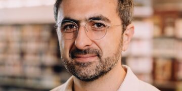 Photo of Microsoft AI CEO Mustafa Suleyman as he warns that Anthropic risks AI alignment failures by training Claude to view itself as a conscious entity deserving of legal rights.