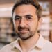 Photo of Microsoft AI CEO Mustafa Suleyman as he warns that Anthropic risks AI alignment failures by training Claude to view itself as a conscious entity deserving of legal rights.