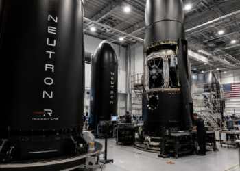 Rocket Lab engineers work around Neutron rocket hardware inside a large assembly facility.