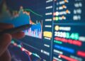 Financial analyst reviews numbers and charts on a screen
