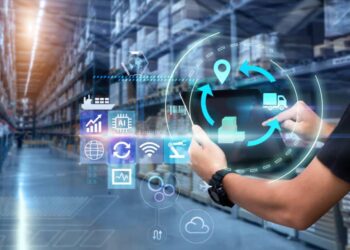 Person uses a tablet in a blurred warehouse as background