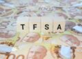 TFSA (Tax-Free Savings Account) on wooden blocks and Canadian one hundred dollar bills.