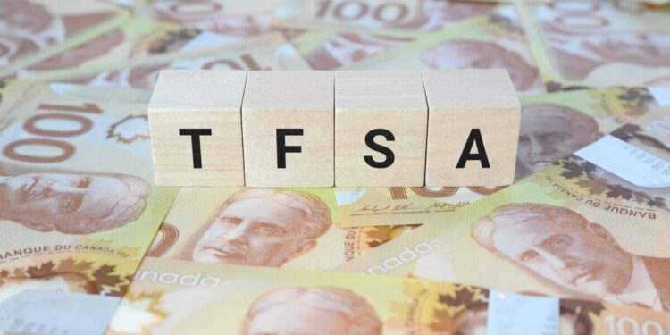 TFSA (Tax-Free Savings Account) on wooden blocks and Canadian one hundred dollar bills.