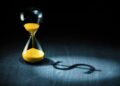 Hourglass projecting a dollar sign as shadow