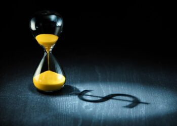 Hourglass projecting a dollar sign as shadow