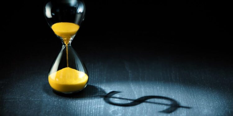 Hourglass projecting a dollar sign as shadow