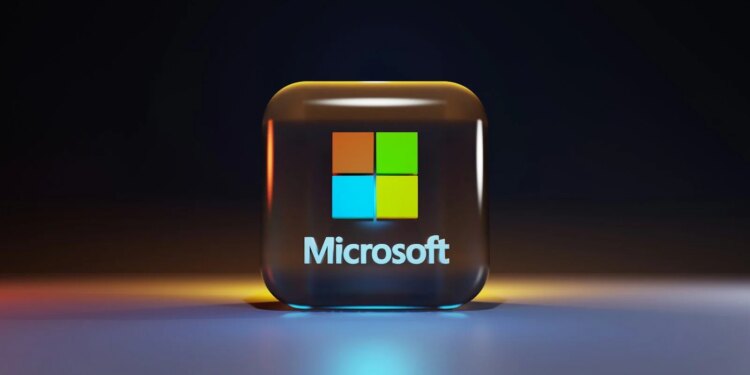 A glossy glass cube with the Microsoft logo on a dark surface