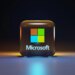 A glossy glass cube with the Microsoft logo on a dark surface