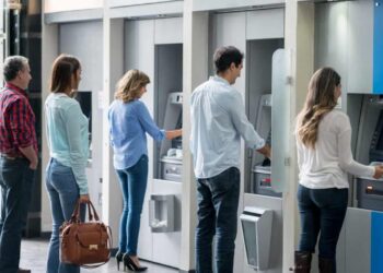 Group of people in a line at an ATM waiting to make a cash withdrawal